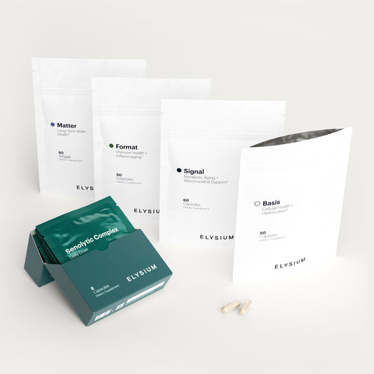 A set of Elysium supplement pouches and a green sachet box on a clean white background. The white pouches are labeled Matter, Format, Signal, and Basis, and the green box contains sensory compound sachets.