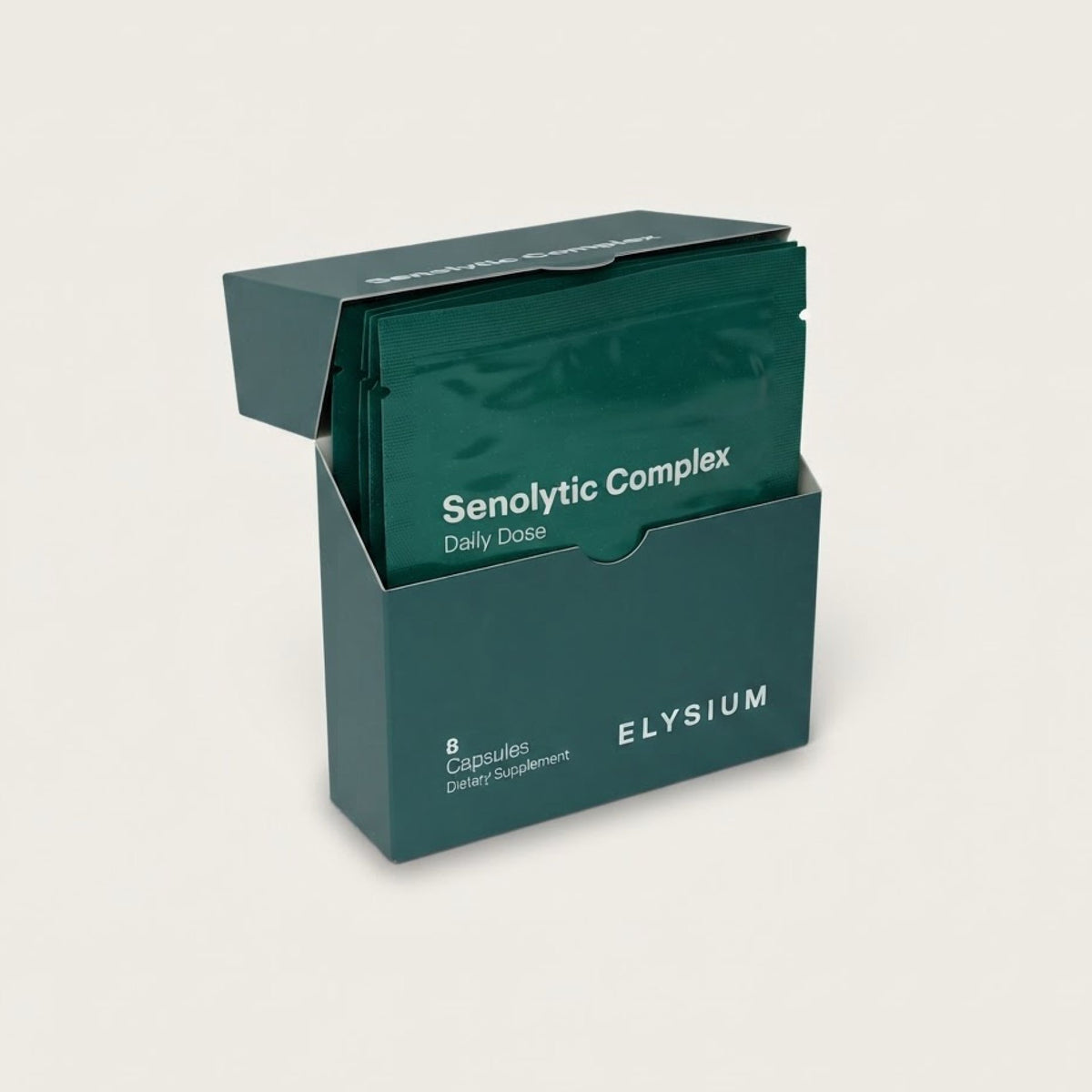 A dark teal-green box of Elysium Senolytic Complex dietary supplement capsules, shown open with individual sachet packets inside, on a light beige background.